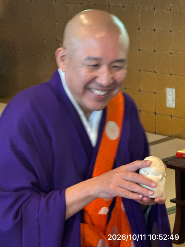 お遺骨をお納めした手元供養仏を、住職が両手で大切にお持ちしています。